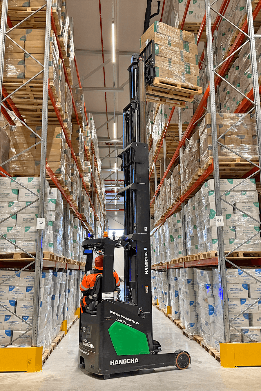 Varastotyöntekijä nostaa trukilla lavallista tavaraa varastohyllyyn GLi:n logistiikkakeskuksen varastossa.